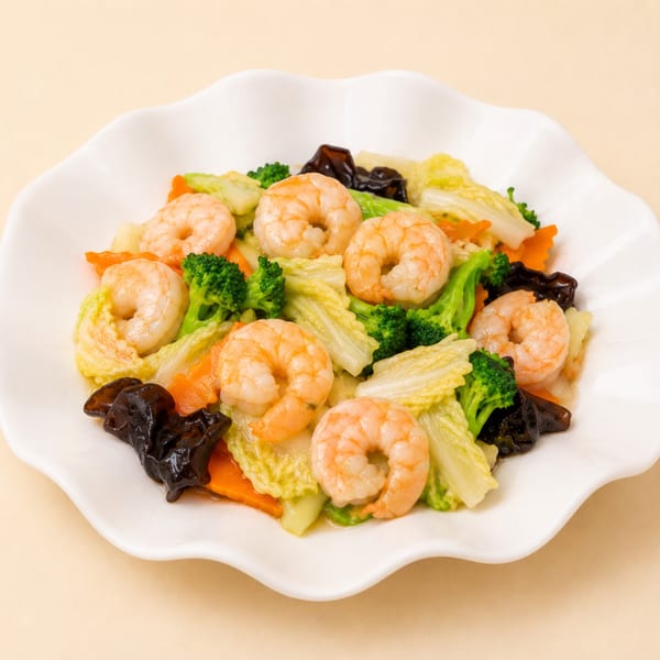 Shrimp stir-fry with broccoli, carrots, napa cabbage, and wood ear mushrooms on a white scalloped plate.