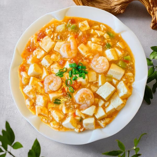 Ginkgo Chinese Restaurant's shrimp and tofu dish in a rich orange sauce, garnished with green onions.